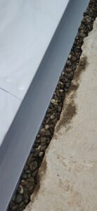 White membrane edge with gravel and concrete